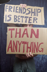 Obraz premium Man holds two signs with the words 