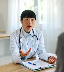 Portrait of a young asian doctor and patient at doctor's office in clinic