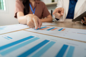 Business Collaboration. Team members analyzing financial data on charts during a meeting.