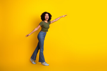 Portrait of a cheerful young woman in casual attire enjoying a playful moment against a vibrant...