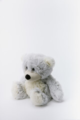 Gray teddy bear stuffed animal sitting on a white background