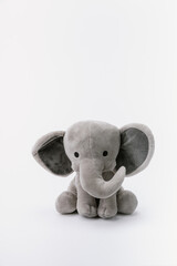 Baby elephant stuffed animal sitting on a white background