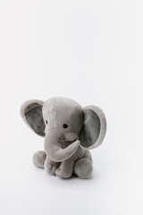 Baby elephant stuffed animal sitting on a white background