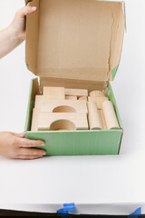 hand opening a box of wooden blocks