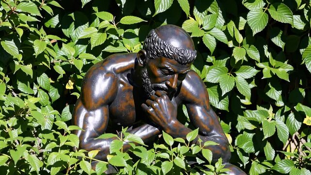 Bronze sculpture emerging from lush foliage environment nature art theme