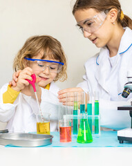 Laboratory examination of a child with test tubes, reagents and a microscope. Selective focus.