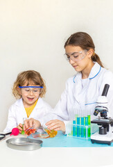 Laboratory examination of a child with test tubes, reagents and a microscope. Selective focus.