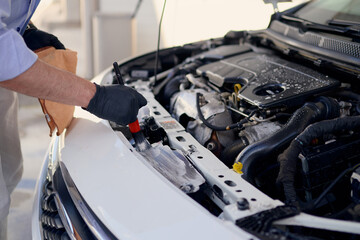 Car maintenance with a technician cleaning the engine bay at an auto shop
