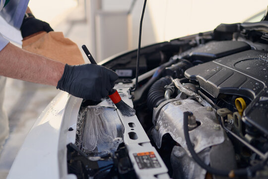 Car maintenance process involves cleaning engine components with care