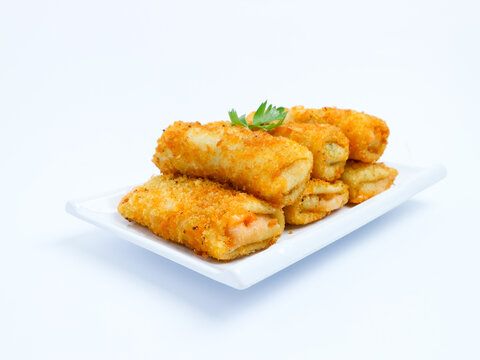 Indonesian crispy risol mayo filled with sausage and soft mayonnaise, served on a white plate with parsley garnish on a white background. Perfect photo of a traditional snack.