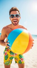 Happy man holding a beach ball on a sunny beach