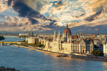 Obraz premium A breathtaking view of the Hungarian Parliament under a stunning sunset sky, reflecting the beauty of Budapest as the day transitions to night