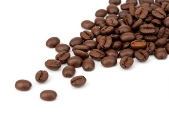 Naklejka premium Roasted coffee beans scattered on white background