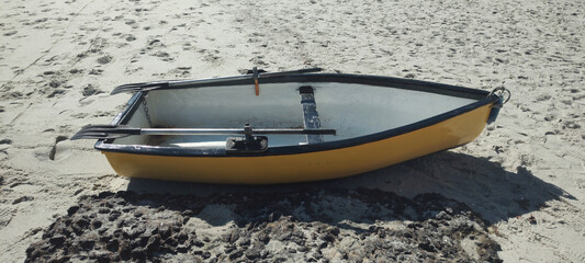 Sand beach sea bright sun reflection transparent wave foam splash water stone detail close texture footprints repetition pattern boat oar dinghy transport sport urban city vacation life