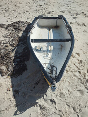 Sand beach sea bright sun reflection transparent wave foam splash water stone detail close texture footprints repetition pattern boat oar dinghy transport sport urban city vacation life