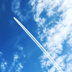 Plane glides through sunset sky with cotton clouds high resolution picture