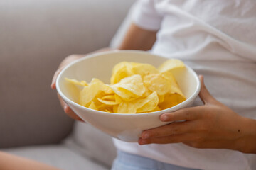 Hand Holding Bowl of Crispy Potato Chips for Snack Time