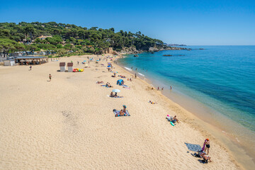 Tourists relaxing on sandy beach at costa brava, calonge, spain