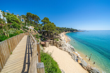 Naklejka premium Wooden walkway leading to a beautiful beach on costa brava, calonge, spain