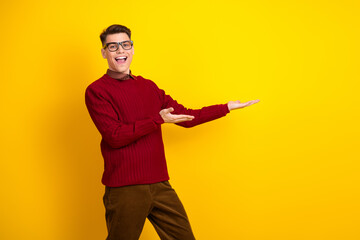 Young Handsome Man Gesturing and Smiling Against Vibrant Yellow Background in Stylish Outfit