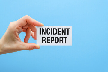 A hand holding a white card that says Incident Report