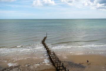 Top down view of wooden groynes and breakers on the North Norfolk Coast