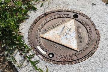 Observation Monitoring Well. Manhole cover, triangle pattern.