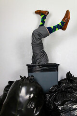 Businessman Stuck in Trash Can Wearing Argyle Socks. Over a Barrel. Concept of Being Sacked or Fired or Being Unfashionable.