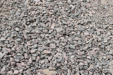 Granite crushed stone. A large pile of crushed stone for repair work. Quartzite crushed stone. Fraction. Construction material for repairing road surfaces and laying sidewalks. Background. Material