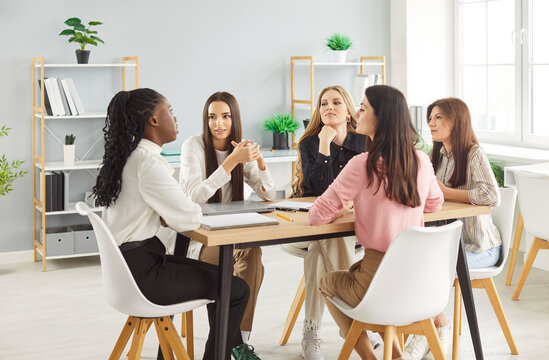 Female community conversation at desk, young girls gathering in club discussing, best friends, multiracial group, women entrepreneurs, leaders, founders of startup, mental health group therapy meeting
