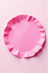 A single pink paper plate sitting on a white surface