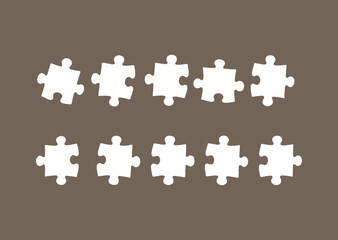 Ten White Puzzle Pieces Arranged in Two Rows on Brown Background