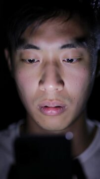 Young man engrossed in smartphone at night