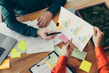 Collaborative coworkers analyzing business reports and graphs during an engaging meeting in a...