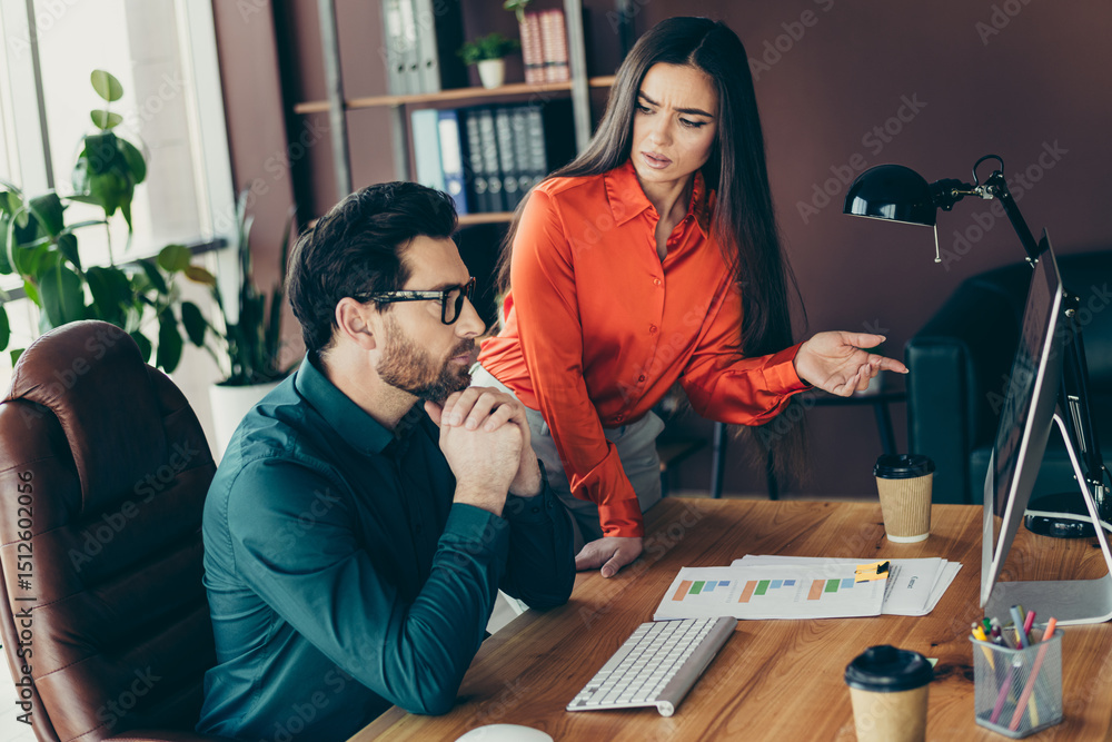 Poster two focused professionals collaborating on a project in a modern office environment with charts and 