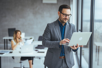 Professional Businessman Working on a Laptop in a Modern Office Setting