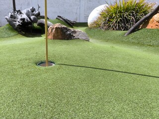 A clean putting green with a hole ready for a perfect shot or hole-in-one. On dinosaur minigolf in Portimao - Portugal – May 5 of 2025