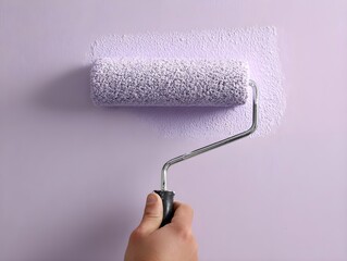 Obraz premium Close-up of roller applying soft-lilac paint with precision creating smooth pastel textures for DIY projects