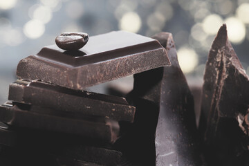 Pieces of dark chocolate on a black wooden background