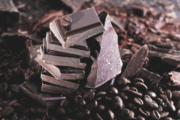 Pieces of dark chocolate on a black wooden background