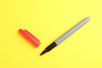 One red marker on yellow background, top view