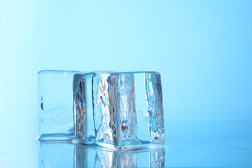 Cubes of clear ice on light blue background, closeup