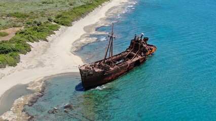 Abandoned shipwreck Dimitrios rests on a serene beach surrounded by clear blue waters in Gytheio...