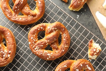 Tasty pretzels with salt and butter on grey table, flat lay