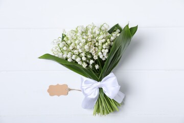 Bouquet of beautiful lily-of-the-valley flowers on white wooden background, top view