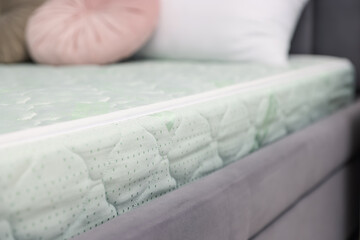 Comfortable bed with new soft mattress and pillows indoors, closeup