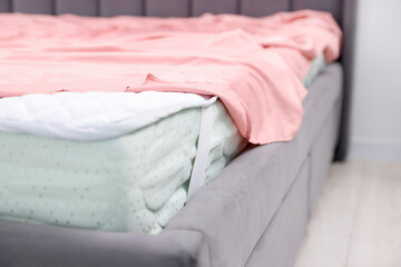 Comfortable bed with new soft mattress and sheet indoors, closeup