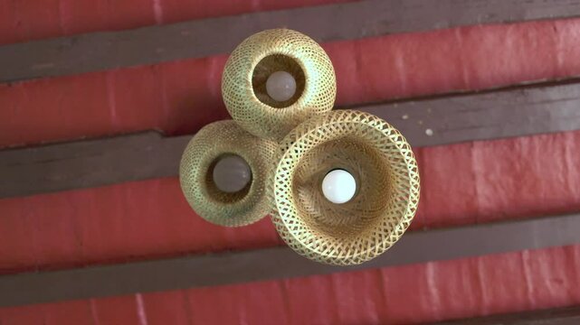 L&aacute;mpara de mimbre o paja colgada de unas trabes en un techo t&iacute;pico mexicano, 