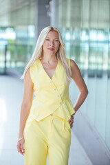 Obraz premium Confident Businesswoman in Yellow Suit Leaving Office on Sunny Day
