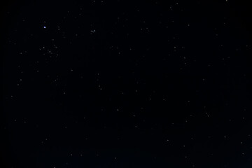 The clear black night sky is dotted with bright glowing stars and constellations on a winter night	
